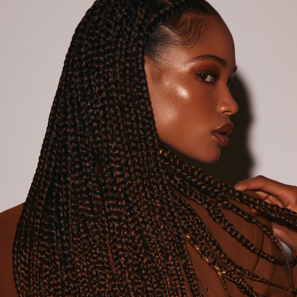 Knotless braids swept over one shoulder